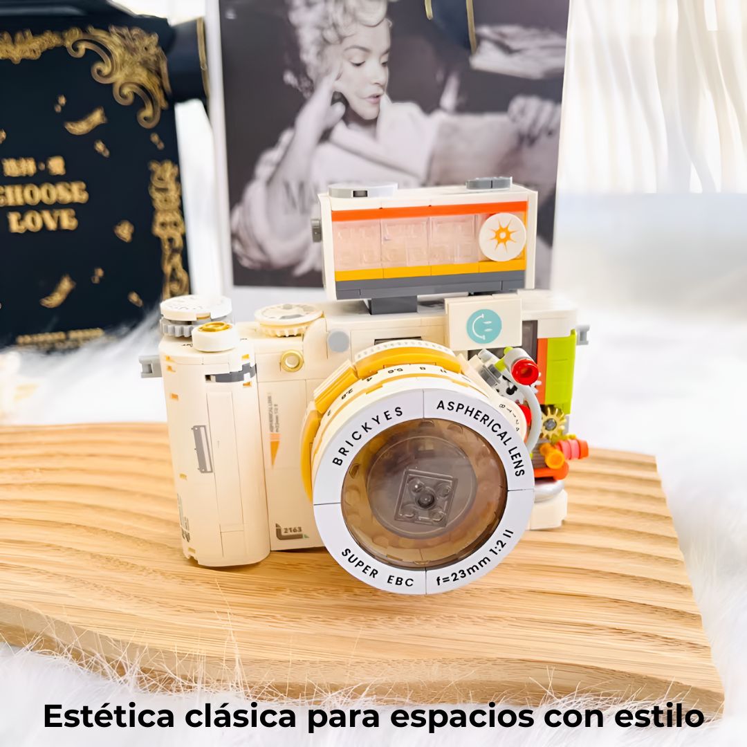 Cámara construida con mini bloques sobre mesa junto a fotografías vintage; pieza decorativa de estética clásica para el hogar.