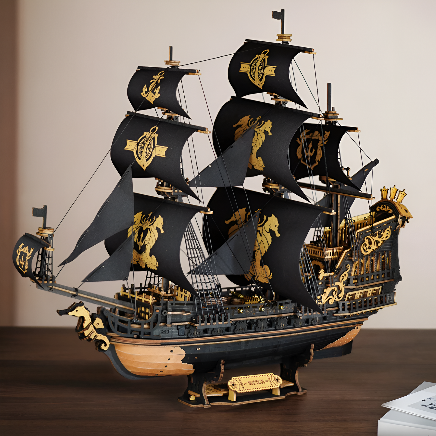 Puzzle 3D de madera — velero de tres mástiles acabado negro y dorado; maqueta naval detallada para exposición.